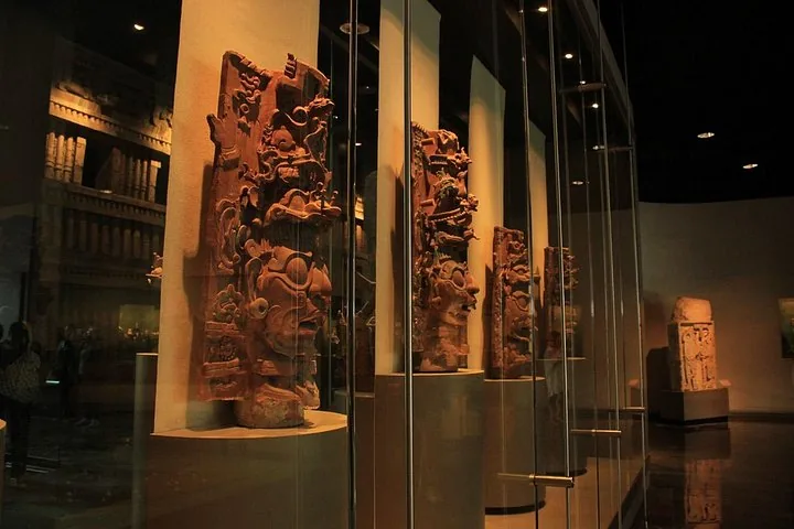 Antike Steinartefakte, die hinter Glas in einer Museumsausstellung gezeigt werden.